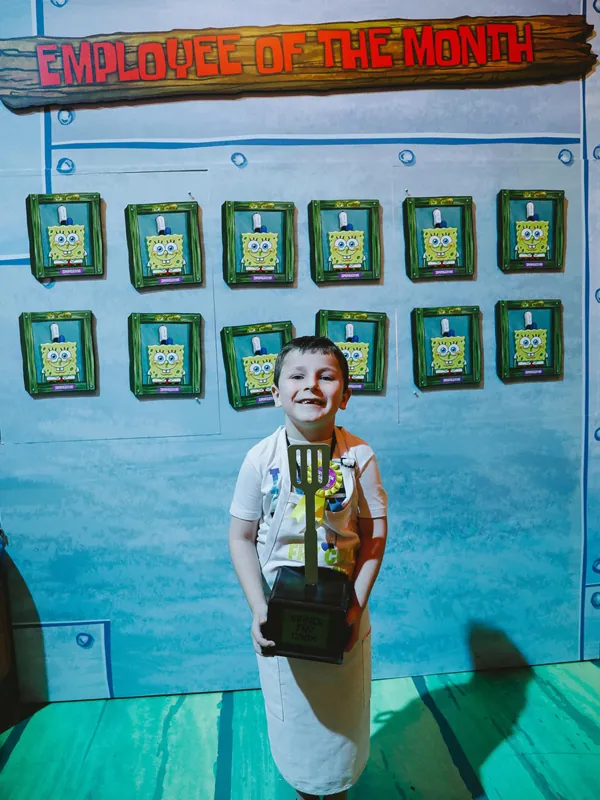 child holding krusty krab employee of the month award in spongebob experiential design booth at comic con